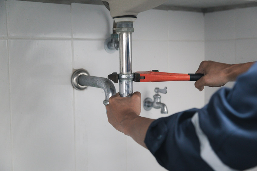 Plumber using a wrench Plumber using a wrench