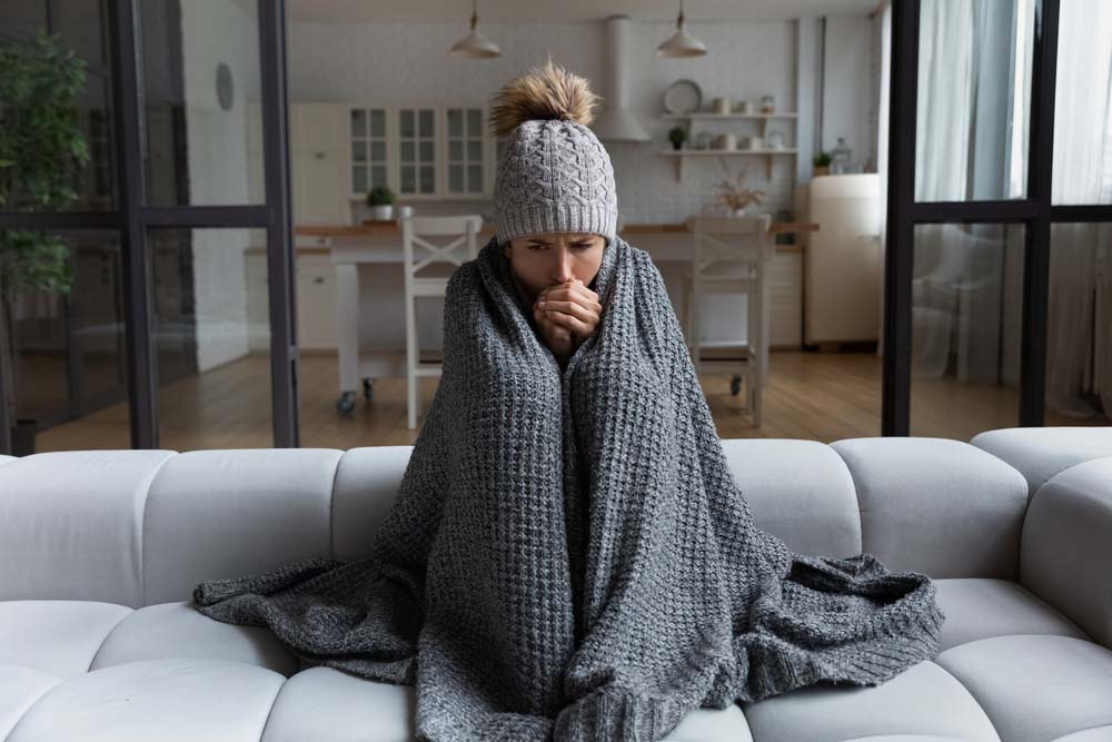 lady at home freezing due to heating system problems lady at home freezing due to heating system problems