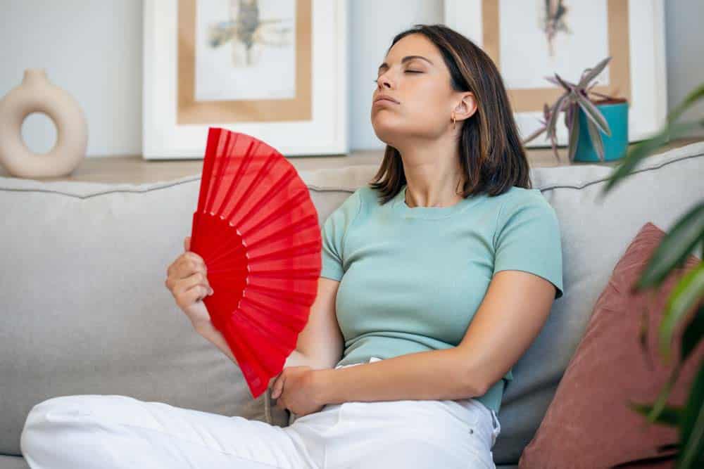 person sweating/fanning themselves