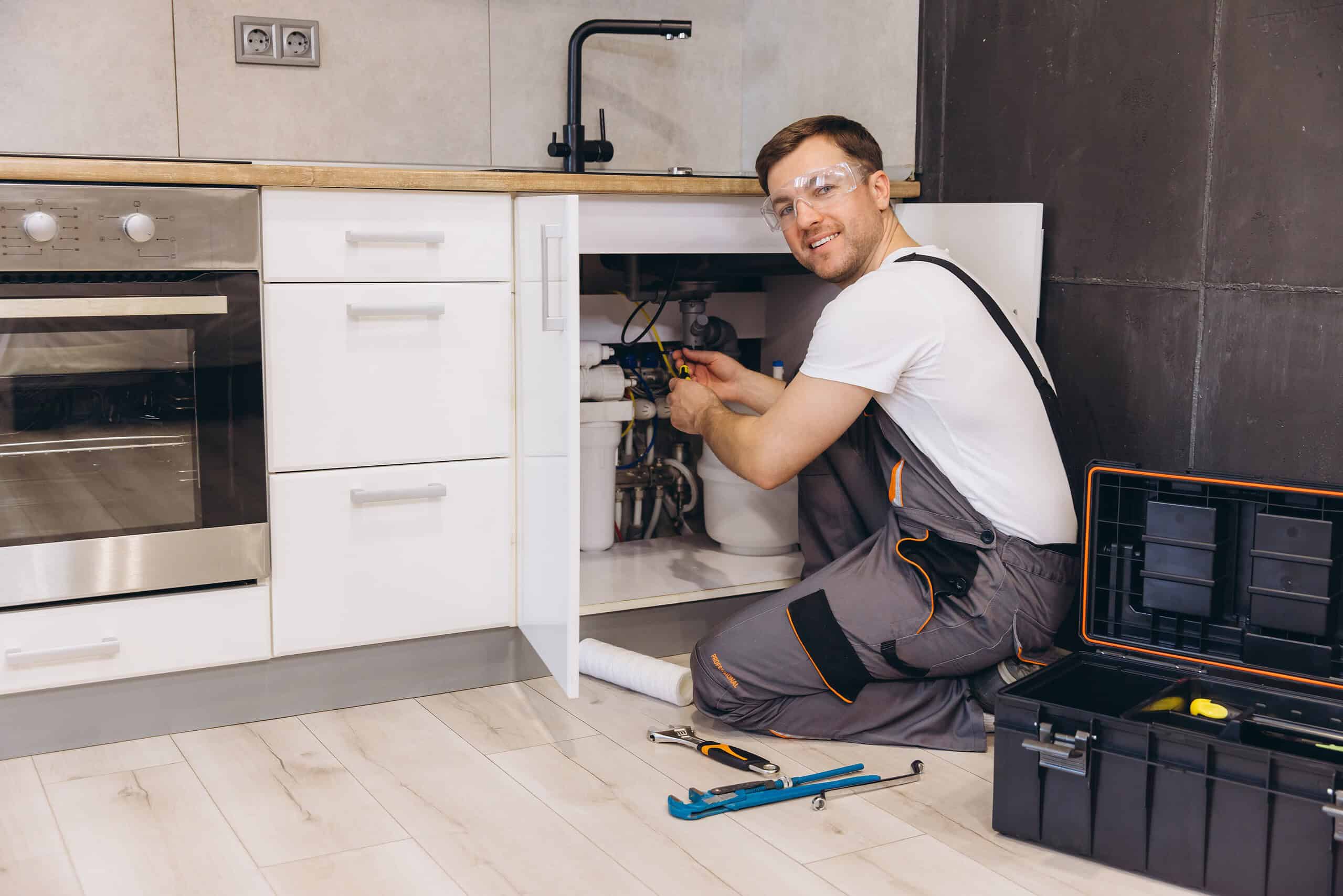 professional plumber working on pipes showing