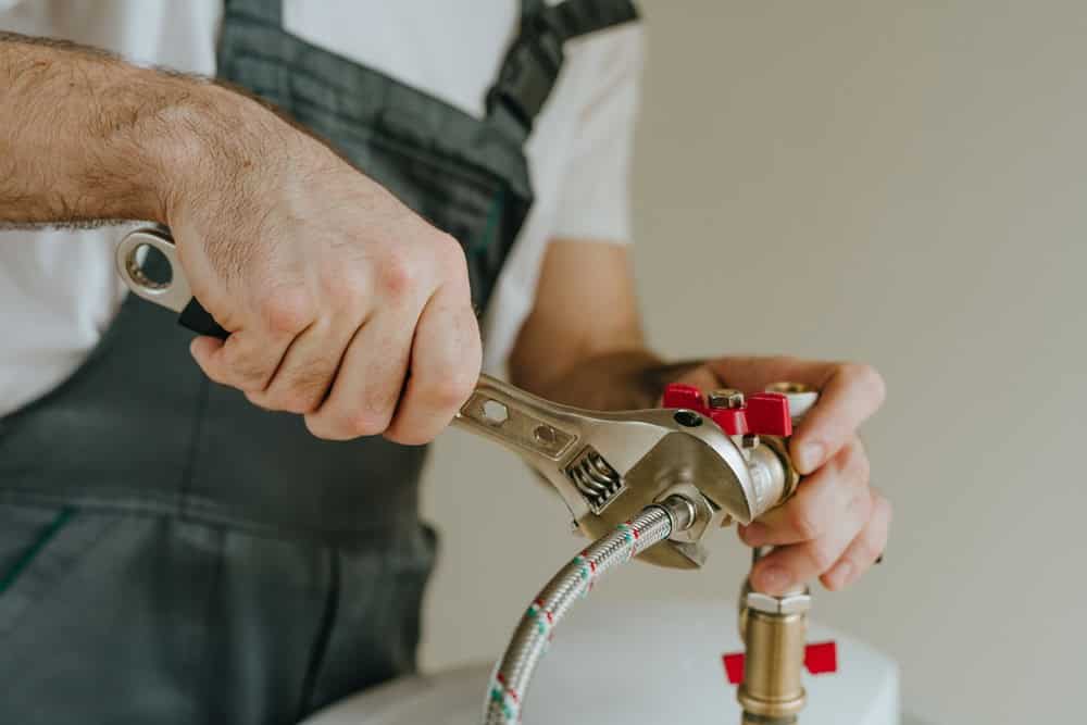 plumber tightening water heater connection